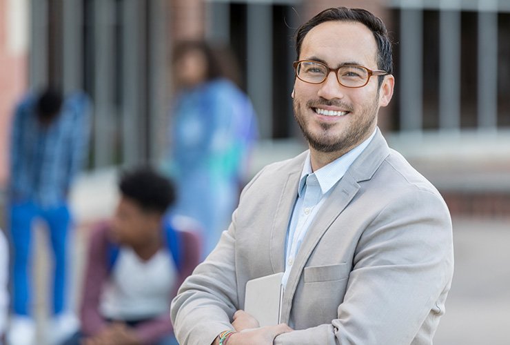 Male teacher wearing glasses smiling at the camera