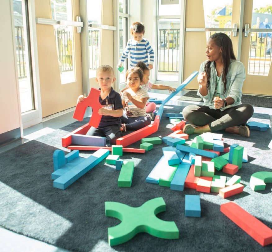 A teacher with four students playing with blocks