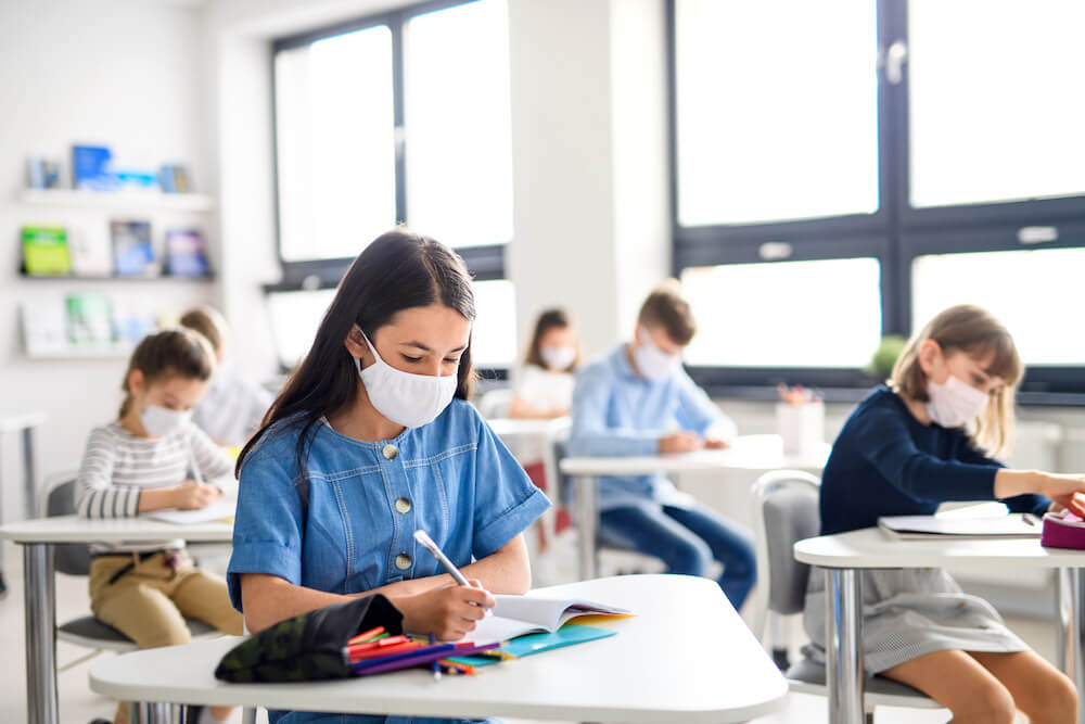 kids with masks working in a classroom