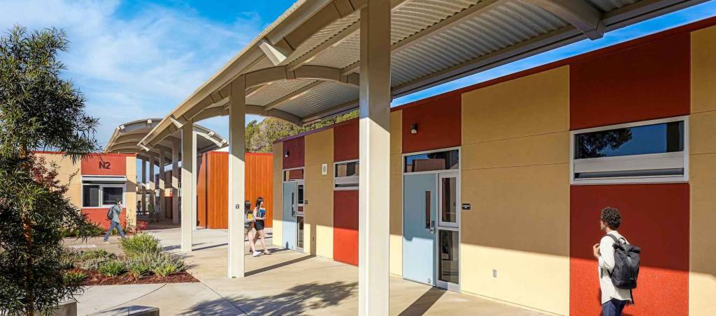 A vibrant school building with a colorful exterior and a walkway leading to its entrance.